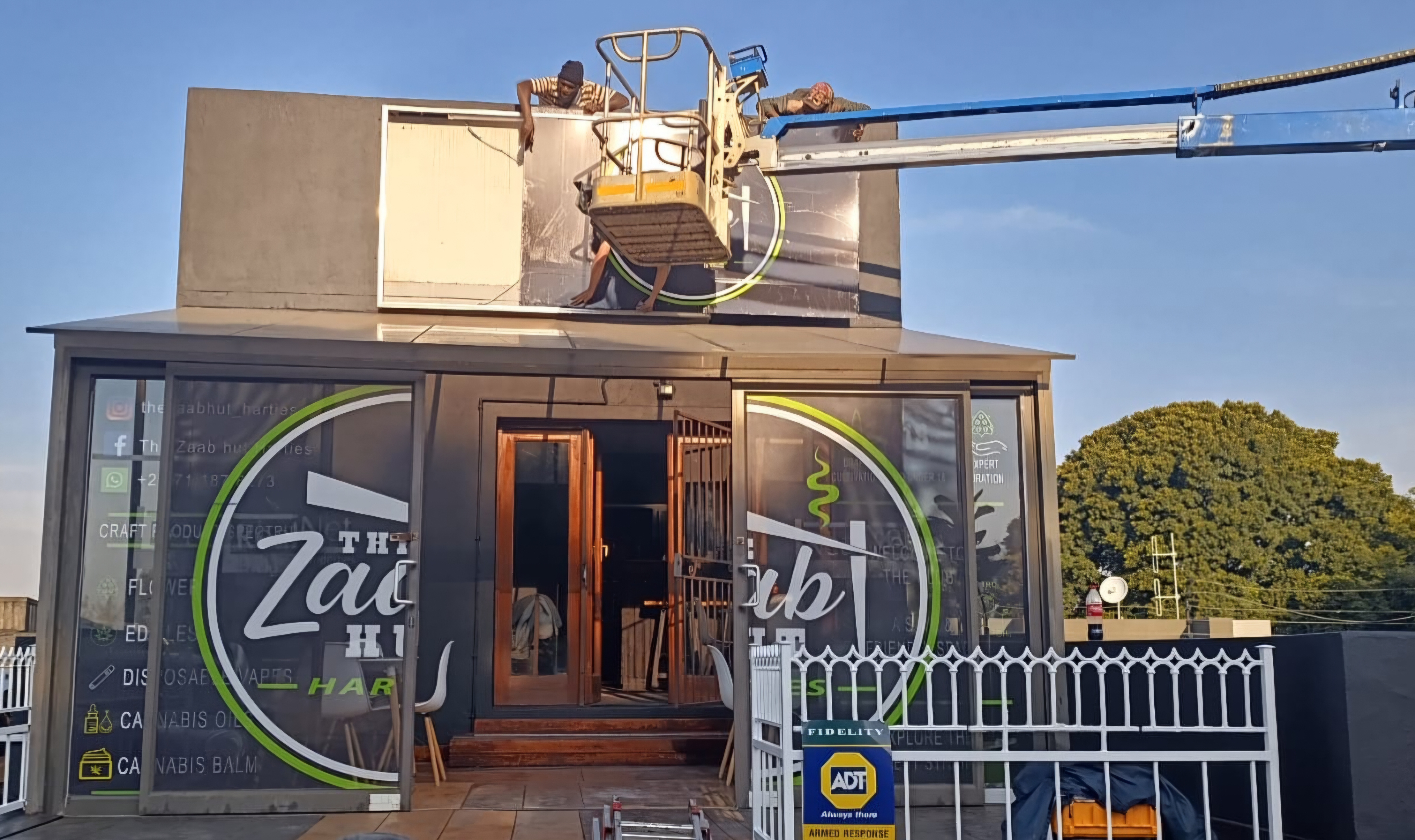 The Zaab Hut storefront full branding installation with workers on cherry picker